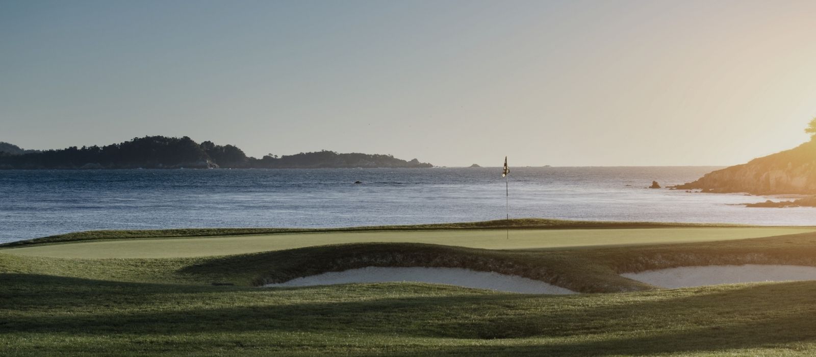 Golf course with water and mountains in the background